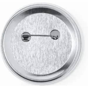 A silver metal badge with a safety pin fastening on the back. The surface has a brushed metallic finish.