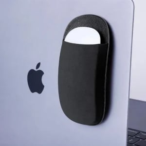 A sleek black accessory holder attached to a laptop, designed to store a small item like a mouse or card.