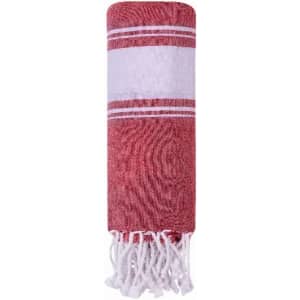 A rolled red towel with white stripes and fringed edges, featuring an overall textured pattern.