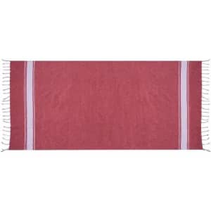 A towel in a deep pink colour with decorative white stripes and fringed edges. It features a plain design.