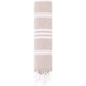 A decorative towel with a striped design in neutral tones, featuring fringed edges. It has a soft and textured appearance.