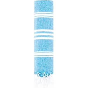 A rolled blue and white striped towel with fringed edges, showcasing a soft, textured fabric.