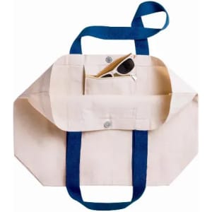 A tote bag in beige with blue straps, featuring a front pocket and a pair of sunglasses inside.