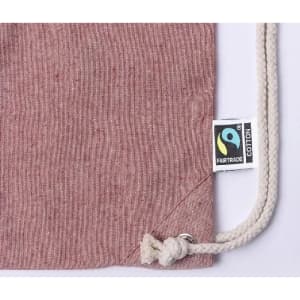 A drawstring bag in a reddish-brown hue, featuring a Fairtrade label and a knotted closure.