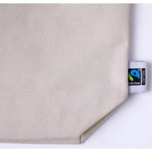 A beige cotton fabric with a visible branding label. The texture appears natural and unbleached.