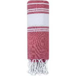A rolled towel in red and white stripes, featuring fringed edges and a simple design. It has a branding logo.