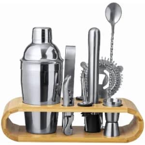 A cocktail shaker set featuring stainless steel tools on a bamboo stand, including a shaker, jigger, strainer, and spoon.