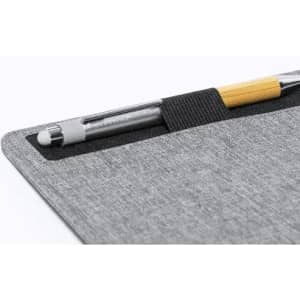 A pen resting in a grey fabric holder, with a wooden accent on the pen's barrel. The holder features a sleek design.