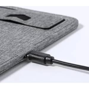 A grey fabric laptop sleeve featuring a charging cable connected to its side. It has a simple, minimalist design.