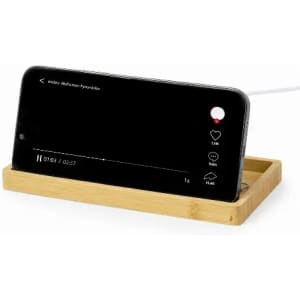 A smartphone on a bamboo docking station, displaying a video with playback controls visible, in a neutral setting.