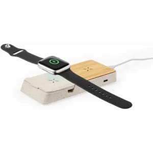 A wireless charger and a smartwatch on a surface, featuring a sleek black strap and a natural wooden charging pad.