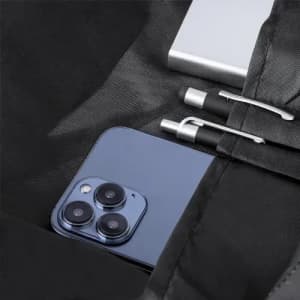 A phone, two pens, and a silver power bank inside a black bag. The phone has a blue rear and three camera lenses.