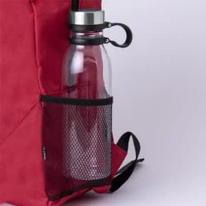 A drink bottle with a clear, glass body and a silver lid, stored in a black mesh pocket on a red backpack.