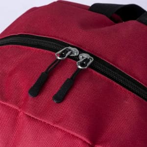 A red backpack with a black zipper and two silver zipper pulls. The texture of the material is visible.