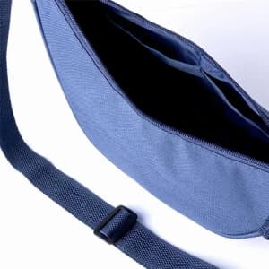 A navy blue bag with a zippered opening, featuring multiple compartments and an adjustable strap.