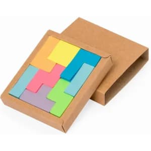 A puzzle-like set of coloured sticky notes in a brown cardboard box. The notes are in shades of yellow, blue, pink, green, and purple.