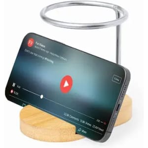 A phone stand with a wooden base and a metal holder, supporting a smartphone displaying a video.