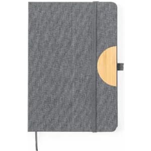 A grey notebook with a bamboo accent and an elastic closure. It features a fabric cover and a ribbon bookmark.