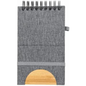 A notebook with a grey fabric cover, spiral binding, and a wooden accent on the base. It features an elastic closure.