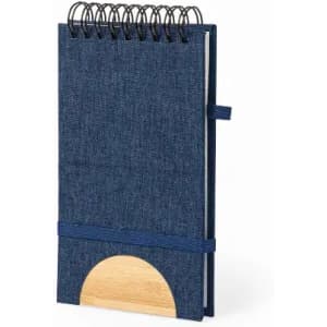 A notebook with a blue denim cover, spiral binding, and a wooden accent at the bottom. It features an elastic band.