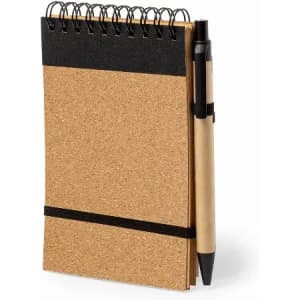 A cork notebook with a black elastic band and a pen attached, featuring a spiral binding.