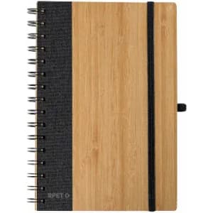 A notebook featuring a bamboo cover with a dark fabric spine and elastic band, secured with metal spiral binding.