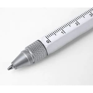 A pen with a silver tip and a ruler printed along its body, featuring a textured grip.
