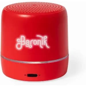 A red portable speaker with a smooth finish and a logo on the front. Features a charging port at the bottom.