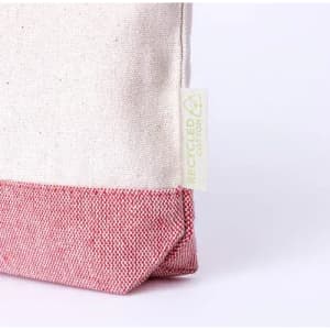 A pouch featuring a cream upper section and a red textured base, with a small tag indicating recycled materials.