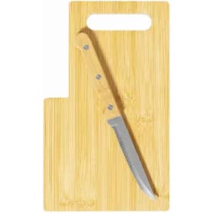 A bamboo cutting board with a serrated knife resting on it, featuring a handle cutout for easy handling.