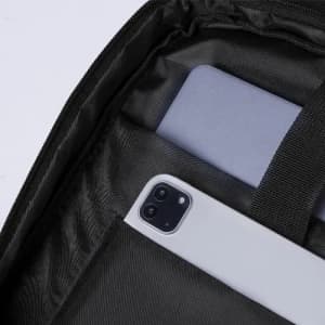 A black bag interior featuring a grey phone and a light grey card holder. The bag has a zip closure.