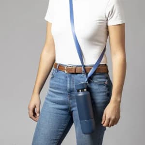 A drink bottle in navy blue, featuring a strap for carrying, held by a person in a casual outfit.