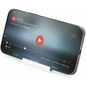 A mobile phone on a stand, displaying a paused video with a red play button on a blurred background.