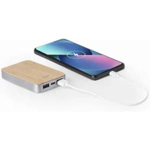 A power bank with a wooden texture connects to a smartphone via a white charging cable.