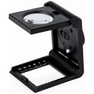 A magnifying glass with a black frame, featuring a foldable design and a small light, with a ruler on the base.