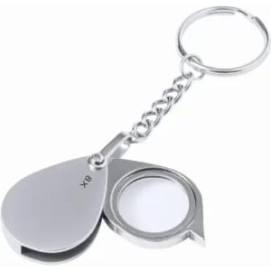 A keychain magnifier with a stainless steel finish, featuring a rounded design and a small lens compartment.