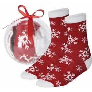Red socks with white snowflake patterns, packaged in a clear round box with a ribbon.