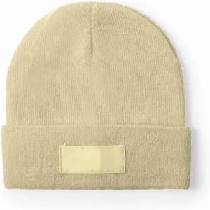 A beanie hat in a light beige colour with a folded cuff and a blank patch on the front.