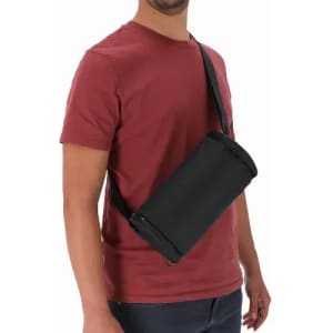 A drink bottle carrier in black, worn on a person’s shoulder with an adjustable strap.