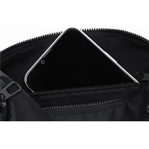 A black bag with a zippered pocket containing a smartphone. The interior is lined with a dark fabric.