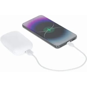A wireless charger in white next to a smartphone, both connected by a charging cable. The phone displays a charging animation.