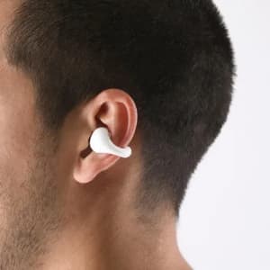 Wireless earphones in white are fitted comfortably in a person's ear, showcasing a sleek design.
