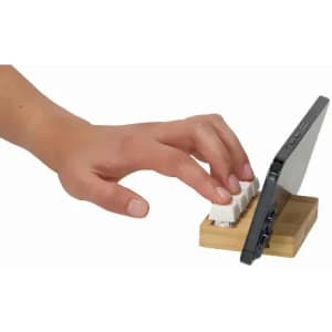 A smartphone stand feature with a hand resting on a mini keyboard, set on a wooden base.