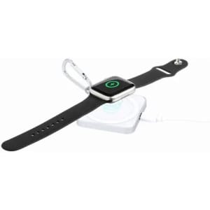 A smartwatch with a black strap rests on a circular charging pad. The pad features a logo.