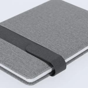 A grey notebook with a fabric cover, featuring an elastic band closure for secure storage.