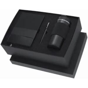 A black gift box containing a drink bottle, a notebook, and a small tool. The bottle features a textured grip and has a logo.