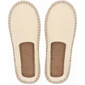 A pair of cream-coloured slippers with a textured sole and woven edges. The interior is soft and cushioned.