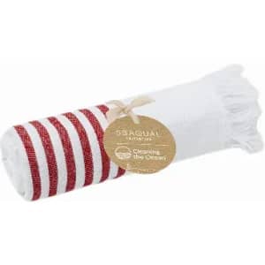 A rolled towel featuring red and white stripes, with a natural tag attached, emphasising environmental sustainability.