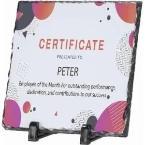 A certificate displayed on a textured slate plaque, featuring vibrant shapes and a black stand.