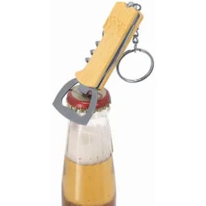 A bottle opener with a wooden handle and metal keychain, resting on a bottle cap with beer inside.